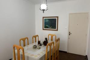 a dining room table and chairs with a white table and a picture at Espaçoso apartamento perto Centro Sul e hospitais in Florianópolis