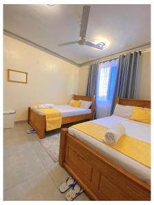 ein Schlafzimmer mit zwei Betten und einem Fenster in der Unterkunft Luxurious Pavilion Nest in Mombasa