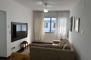 a living room with a couch and a flat screen tv at Espaçoso apartamento perto Centro Sul e hospitais in Florianópolis