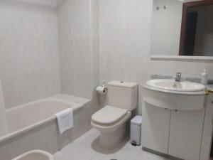 a white bathroom with a toilet and a sink at Apartamento Ziralla- con Garaje Gratis in Allariz