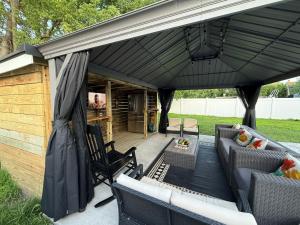 ロングブランチにあるGround-level bed bath house1mi to the beach sleep8の黒いカバーと椅子のある屋外パティオ