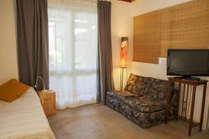 een woonkamer met een bank en een televisie bij Cal Teixidor in Mediona