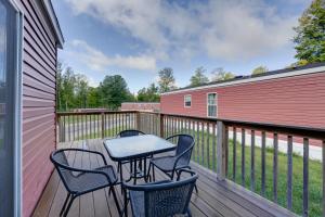 a table and chairs on a deck with a fence at Cassopolis Cabin with On-Site Fishing Pier! in Cassopolis