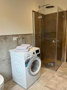 a washing machine in a bathroom with a shower at Ferienwohnung Sunnseitn in Bayrischzell