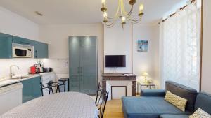 a kitchen and a living room with a blue couch at Les Meublés d'Etigny in Luchon