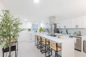 a kitchen with white cabinets and a island with bar stools at Magnificent Beach Front Condo - Flagler Ave - 111 in New Smyrna Beach