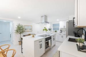 a white kitchen with white cabinets and appliances at Magnificent Beach Front Condo - Flagler Ave - 111 in New Smyrna Beach
