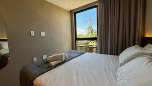 ein Schlafzimmer mit einem Bett und einem großen Fenster in der Unterkunft Casa 3 Suítes Piscina e Hidro para até 9 pessoas in Tatuamunha