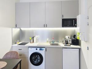 a kitchen with a washing machine and a sink at Le Trinity tout confort avec parking privé au centre ville in Vendôme