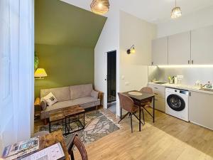 a living room with a couch and a kitchen at Le Trinity tout confort avec parking privé au centre ville in Vendôme