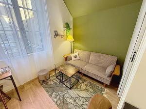 a living room with a couch and a table at Le Trinity tout confort avec parking privé au centre ville in Vendôme