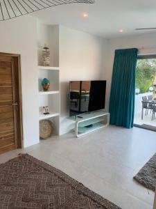 ein Wohnzimmer mit einem Flachbildfernseher an der Wand in der Unterkunft Villa Mandalay - By Sp Villa Management in Nathon Bay + 25 Fotos