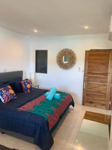 ein Schlafzimmer mit einem Bett mit blauen Kissen und einem Spiegel in der Unterkunft Villa Mandalay - By Sp Villa Management in Nathon Bay