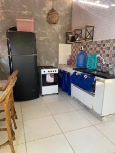 a kitchen with a black refrigerator and a stove at Hostel Itaparica in Itaparica Town