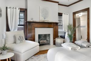 a living room with two white couches and a fireplace at Southern Tides- Pool, Fire Pit & Games in Birmingham +58 photos