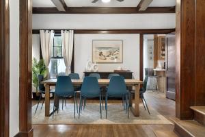 a dining room with a table and blue chairs at Southern Tides- Pool, Fire Pit & Games in Birmingham
