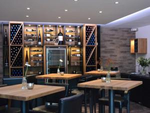 ein Restaurant mit Tischen und Regalen aus Weinflaschen in der Unterkunft Hotel Am Hirschhorn - Wellness - Spa - and more in Wilgartswiesen