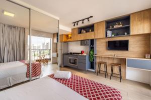 a bedroom with a bed and a kitchen with a counter at Studio mobiliado ao lado do aeroporto de Congonhas in Sao Paulo