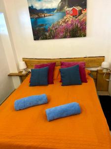 un lit orange avec des oreillers bleus et un tableau au mur dans l'établissement Casa Gran Danés, à Santa Cruz de Tenerife 8 autres photos