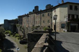 un antiguo edificio de piedra con una luz de la calle delante de él en Palazzo Tarlati - Hotel de Charme - Residenza d'Epoca en Civitella in Val di Chiana