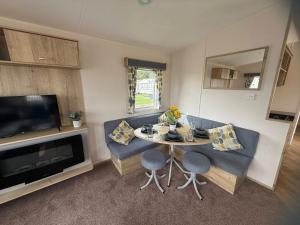 ein Wohnzimmer mit Tisch und Stühlen und einem Fernseher in der Unterkunft Skegness Retreats The meadows 13 Golden Palm Resort Chapel st leonards in Chapel Saint Leonards