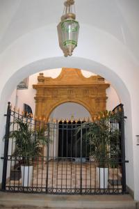 an archway with a gate with plants and a chandelier at Casa Rebella in Marsala