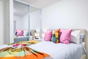 a bedroom with a bed with pink and colorful pillows at Aquaville Dorado Moderna Villa 5 in Dorado