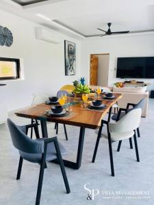 a dining room with a wooden table and chairs at Villa Noi By Sp Villa Management in Koh Samui 