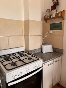 a kitchen with a stove and a toaster at Experiencia Brown a Mtros Sanatorio Juncal in Temperley