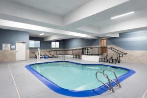 Una gran piscina en una sala amplia con sillas y una escalera. en Holiday Inn Express Redding North by IHG, en Redding