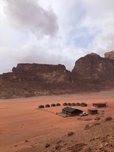 un grupo de tiendas en el desierto cerca de las montañas en Star Walk Camp & Tours, en Wadi Rum