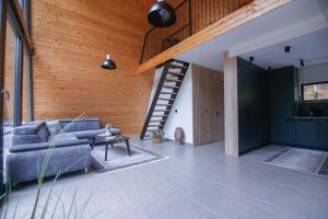 a living room with a couch and a wooden wall at Golf Forest Creek Villas in Zavidovići