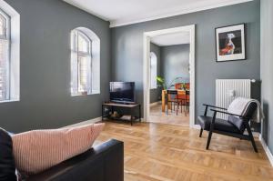 a living room with a couch and a television at Cozy central flat with terrace in Hinge