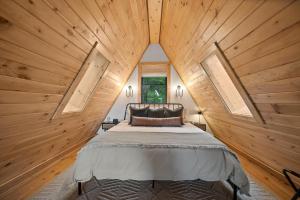 a bedroom with a large bed in a wooden wall at Alpine A-Frame at Calm Ridge Treehouses in Boone