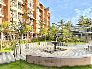 a fountain in a park in front of a building at Rustic 1BHK Apartment, Gym, Pool, Amenities - Near Candolim Beach in Candolim