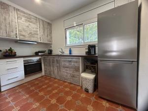 a kitchen with a stainless steel refrigerator and a window at Casa Fritz in Llagostera