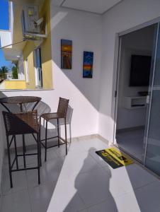 a room with chairs and a table and a television at Apartamento 02 quartos - 06 pessoas in Santa Cruz Cabrália