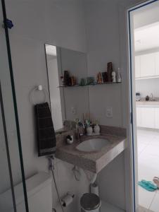 a bathroom with a sink and a mirror at Apartamento 02 quartos - 06 pessoas in Santa Cruz Cabrália