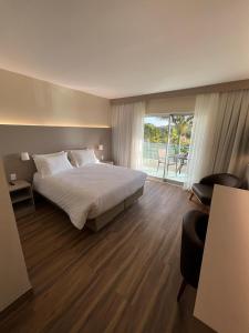 a bedroom with a bed and a sliding glass door at Hotel Mirante São Brás in São Brás do Suaçuí