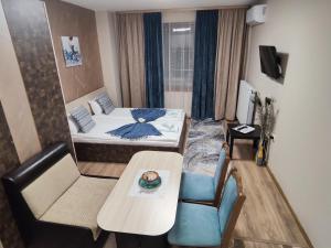 a small room with a bed and a table at Madini apartment in Velingrad