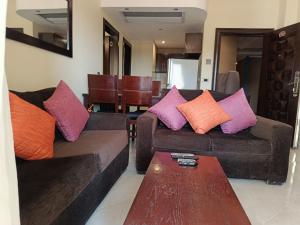 a living room with two couches and a coffee table at SHL Hurghada Hotel Apartments Sahl Hasheesh - By SAHLHOMES in Hurghada