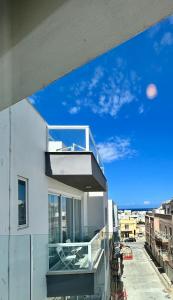 a balcony on a white building with a blue sky at Luxury Private Suite & Room St Julians Central - Shared Apt in Is-Swieqi +14 photos