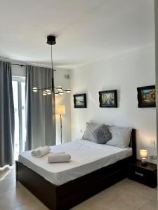 a bedroom with a large bed with white sheets at Luxury Private Suite & Room St Julians Central - Shared Apt in Is-Swieqi