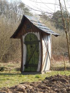 a small dog house with a door in the grass at Chata Bavor Látkovce in Uhrovec