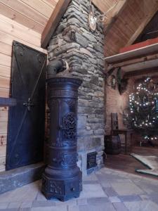 a large fireplace in a room with a christmas tree at Chata Bavor Látkovce in Uhrovec