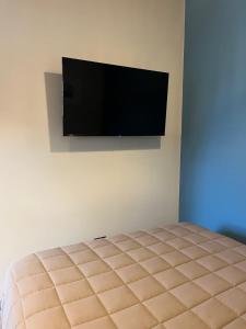 a bedroom with a bed and a flat screen tv on the wall at Las Olas Miramar in Miramar