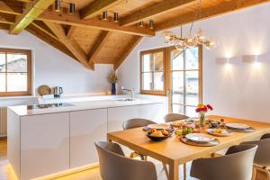a kitchen and dining room with a wooden table and chairs at Tagenhof Mountain Living in Meluno