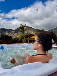 a woman sitting in a swimming pool at Pousada Bela Vista do Ismail - Lapinha da Serra in Santana do Riacho