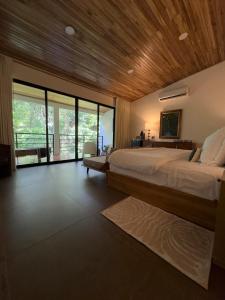 a bedroom with a large bed with a wooden ceiling at Jungle Bungalow at Oropel Lodge in Puerto Viejo