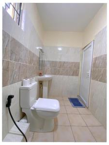 ein Badezimmer mit Toilette und Waschbecken in der Unterkunft Luxurious Pavilion Nest in Mombasa + 6 Fotos
